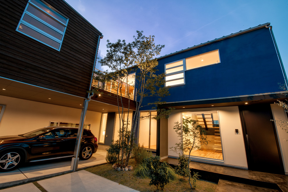 Стильный дизайн: синий частный загородный дом в стиле модернизм с односкатной крышей и металлической крышей - последний тренд