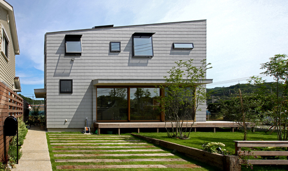 Inspiration för ett funkis grått hus, med två våningar och fiberplattor i betong
