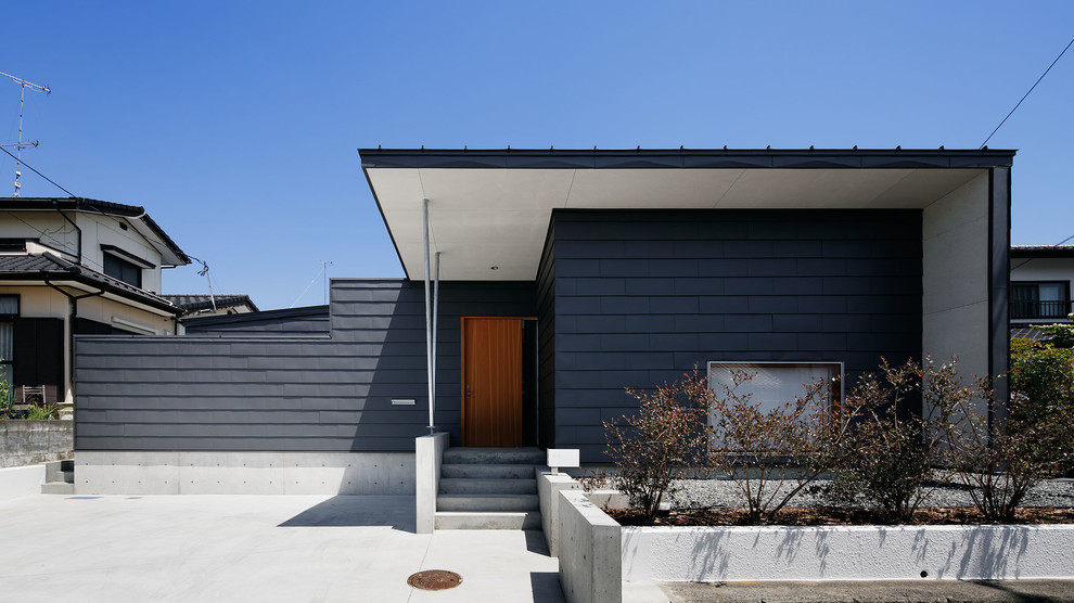 Exemple d'une façade de maison grise tendance de plain-pied avec un toit en appentis et un toit en métal.