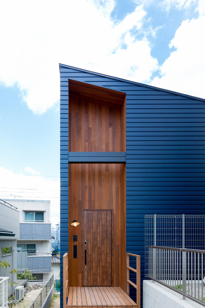 Aménagement d'une façade de maison bleue contemporaine avec un toit en appentis.