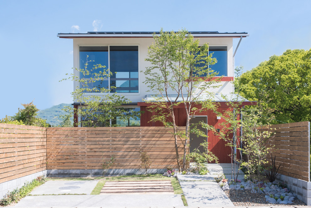 Aménagement d'une façade de maison multicolore asiatique en bois à un étage avec un toit à deux pans et un toit en métal.