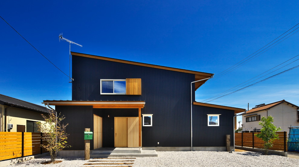На фото: двухэтажный, деревянный, серый дом в современном стиле с односкатной крышей с