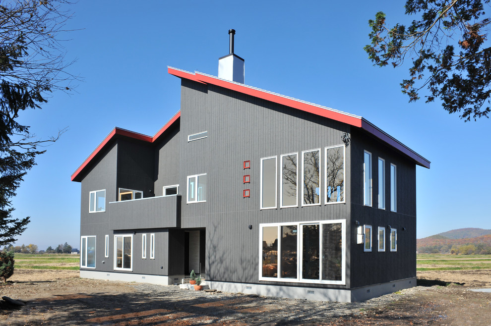 Свежая идея для дизайна: двухэтажный дом в современном стиле с комбинированной облицовкой и двускатной крышей - отличное фото интерьера