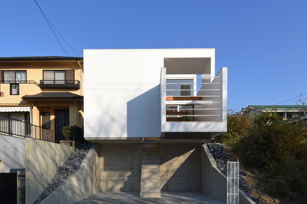 This is an example of a white contemporary house exterior in Nagoya with a flat roof.