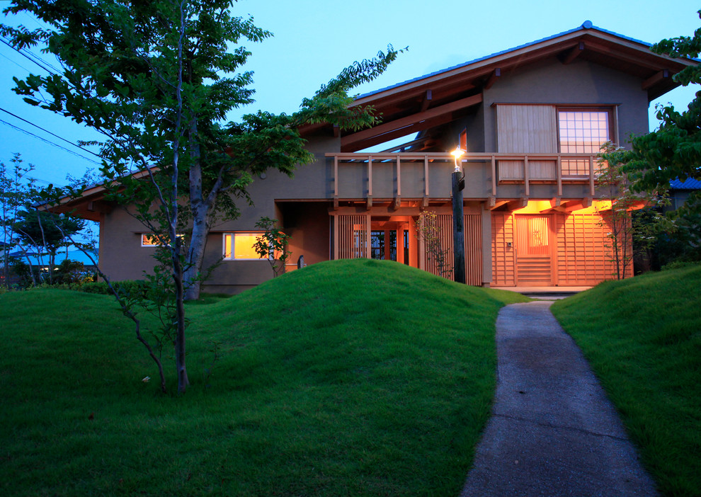 Zen beige two-story gable roof idea in Other