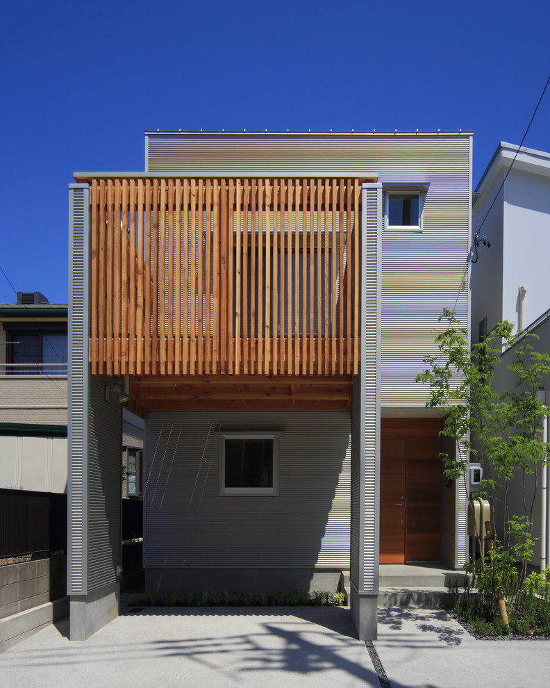 Réalisation d'une façade de maison grise minimaliste à un étage avec un toit en appentis et un toit en métal.