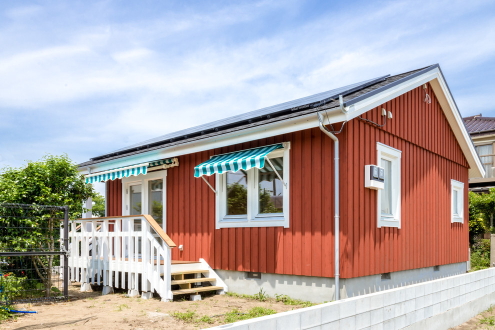 Идея дизайна: маленький, одноэтажный, деревянный, красный частный загородный дом в скандинавском стиле с двускатной крышей и крышей из смешанных материалов для на участке и в саду