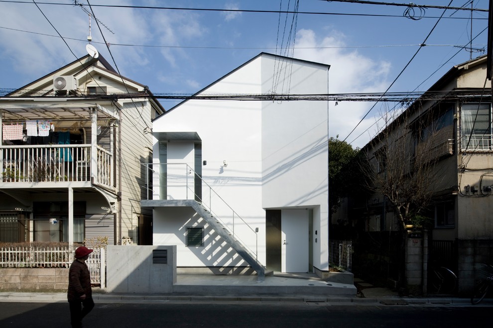 Kleines, Zweistöckiges Modernes Wohnung mit Putzfassade, weißer Fassadenfarbe, Satteldach und Blechdach in Tokio