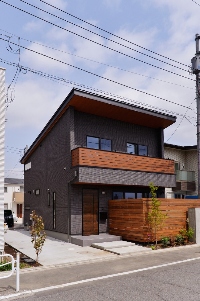 Zweistöckiges Modernes Einfamilienhaus mit grauer Fassadenfarbe, Pultdach und Blechdach in Tokio Peripherie