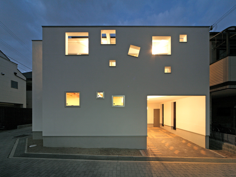 Foto della facciata di una casa bianca contemporanea a due piani con tetto piano