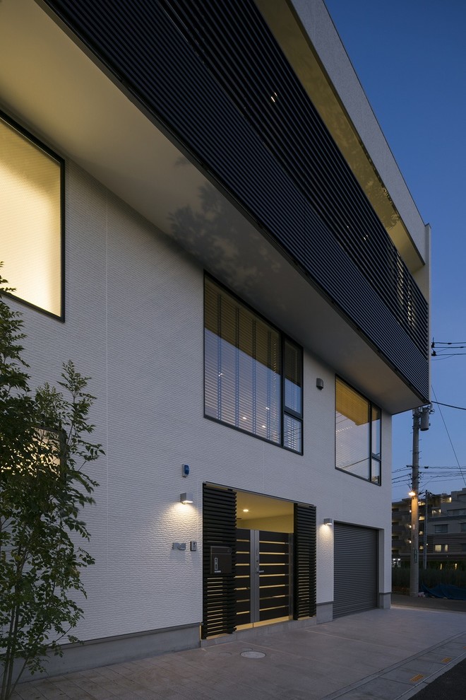 Esempio della facciata di una casa ampia beige moderna a tre piani con rivestimento in mattoni