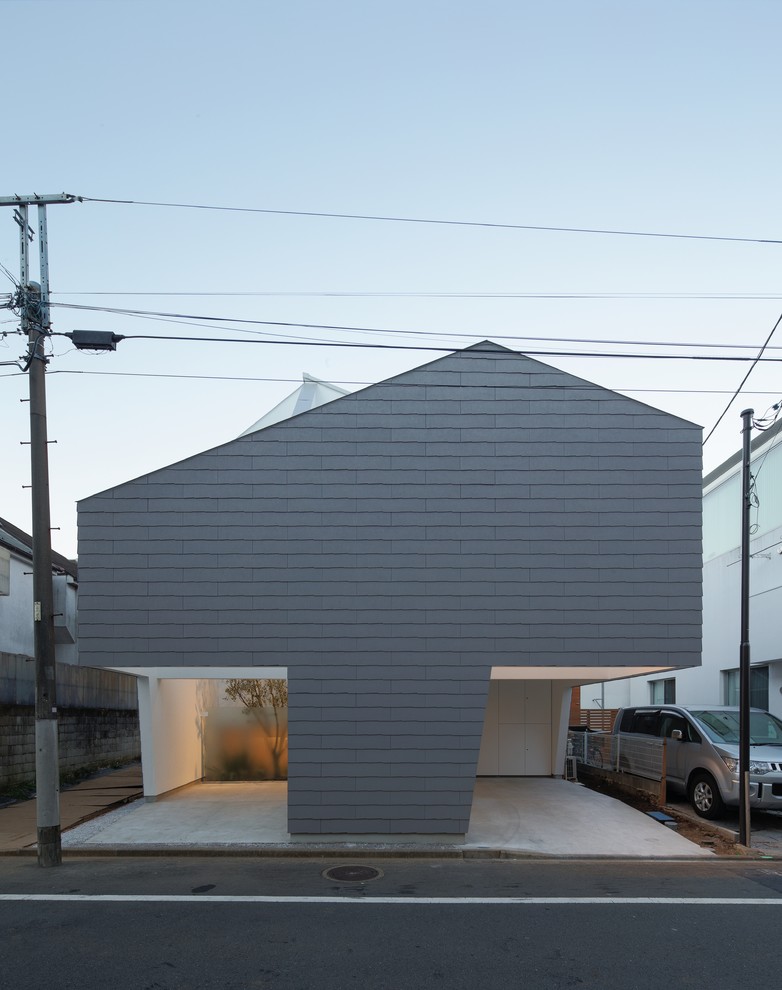 Idée de décoration pour une façade de maison grise design avec un toit à deux pans.