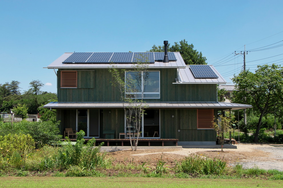 Idées déco pour une façade de maison verte asiatique en bois avec un toit à deux pans.