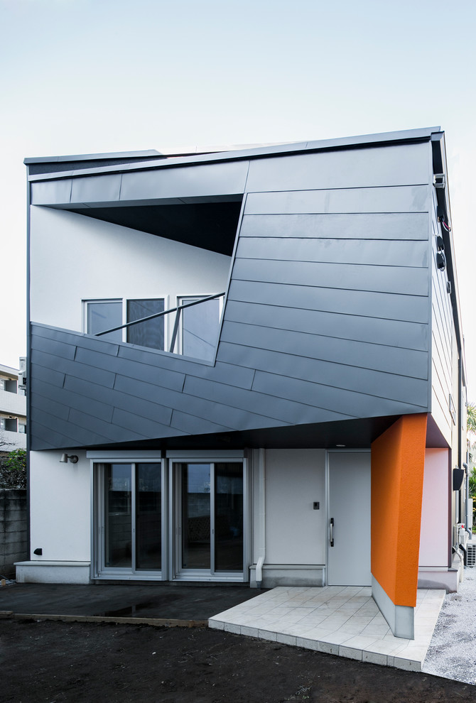 Bild på ett funkis flerfärgat hus, med platt tak