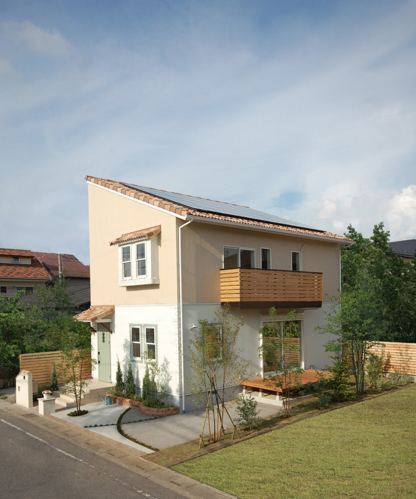 Foto de fachada beige campestre de tamaño medio de dos plantas con revestimientos combinados, tejado de un solo tendido y tejado de teja de barro