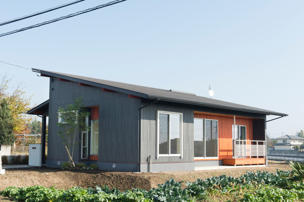 Asiatische Holzfassade Haus mit grauer Fassadenfarbe und Pultdach in Sonstige
