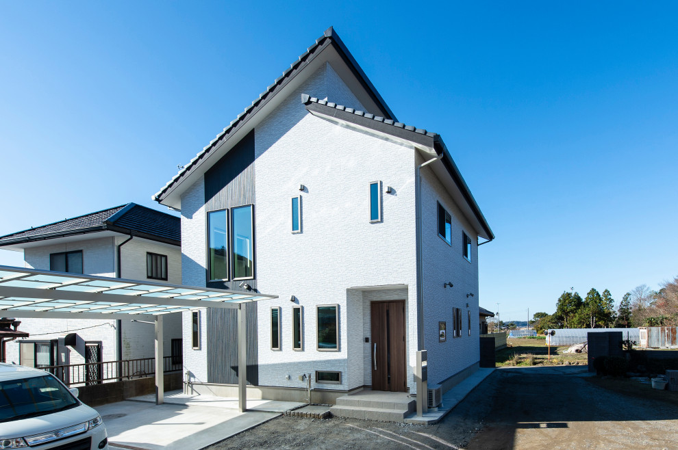 Aménagement d'une grande façade de maison blanche moderne à un étage avec un revêtement mixte, un toit en appentis et un toit en tuile.
