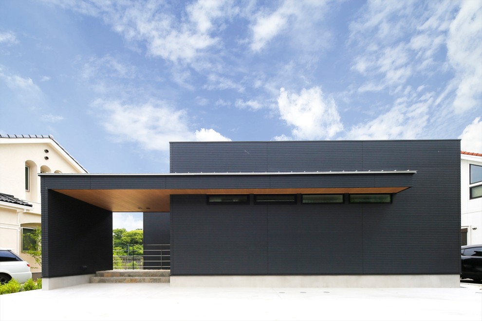 Immagine della facciata di una casa nera moderna con tetto piano