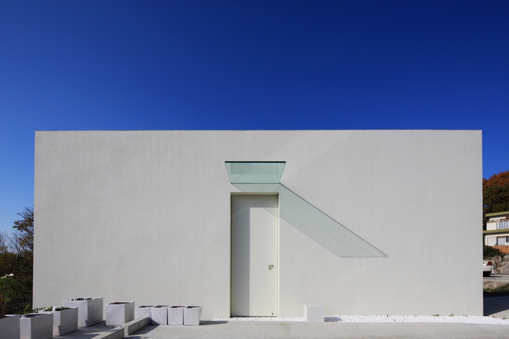 Ejemplo de fachada blanca minimalista con tejado plano