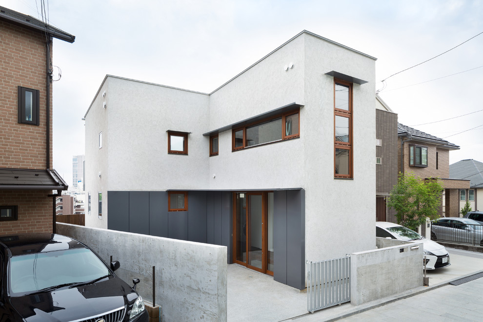 На фото: двухэтажный, белый частный загородный дом среднего размера в современном стиле с облицовкой из цементной штукатурки, односкатной крышей и металлической крышей