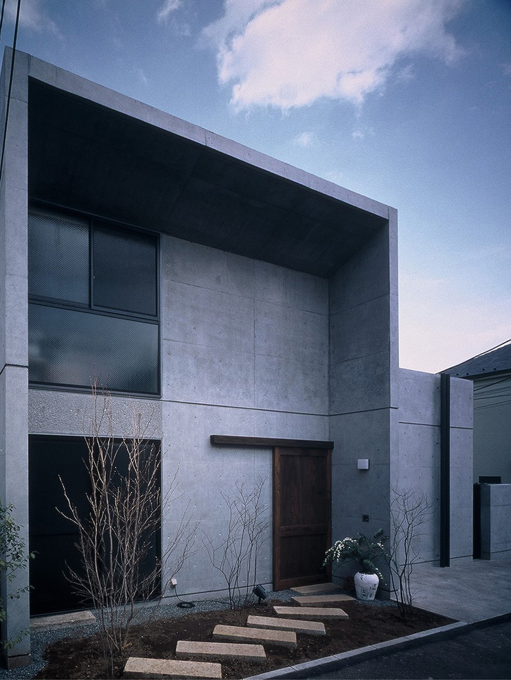 Immagine della villa grigia contemporanea a due piani con rivestimento in cemento e tetto piano