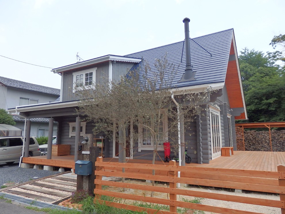 Cette photo montre une façade de maison grise scandinave en bois de taille moyenne et à un étage avec un toit à deux pans et un toit en métal.