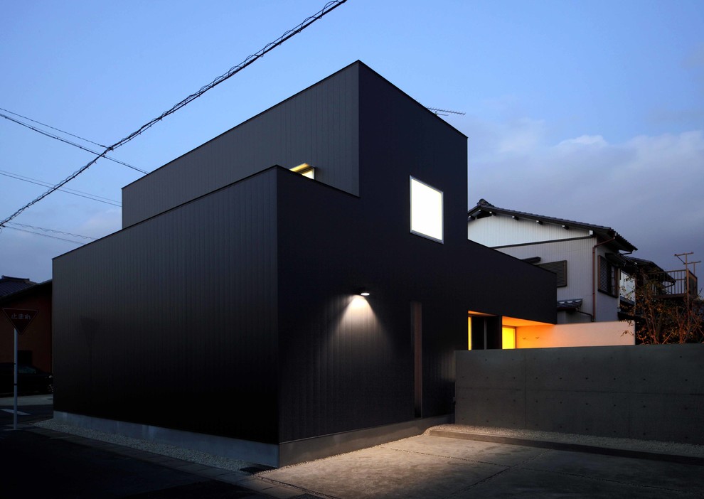 Kleines, Zweistöckiges Modernes Einfamilienhaus mit Metallfassade, schwarzer Fassadenfarbe, Pultdach und Blechdach in Sonstige