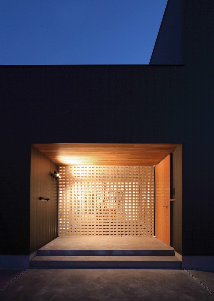 Idée de décoration pour une petite façade de maison noire minimaliste à un étage avec un toit en appentis et un toit en métal.