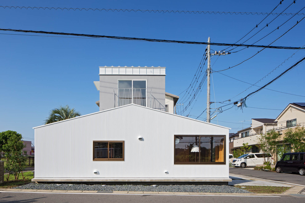 Mittelgroßes, Zweistöckiges Skandinavisches Einfamilienhaus mit Metallfassade, weißer Fassadenfarbe, Satteldach und Blechdach in Tokio