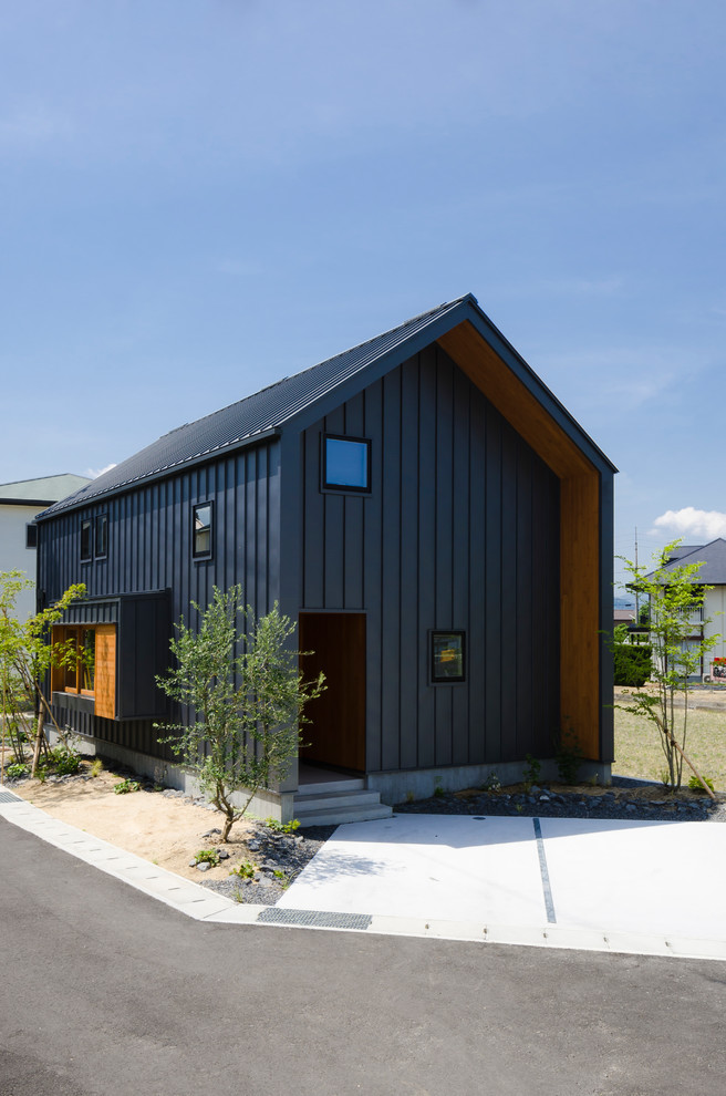 This is an example of a medium sized and gey contemporary two floor detached house in Other with a pitched roof and a metal roof.