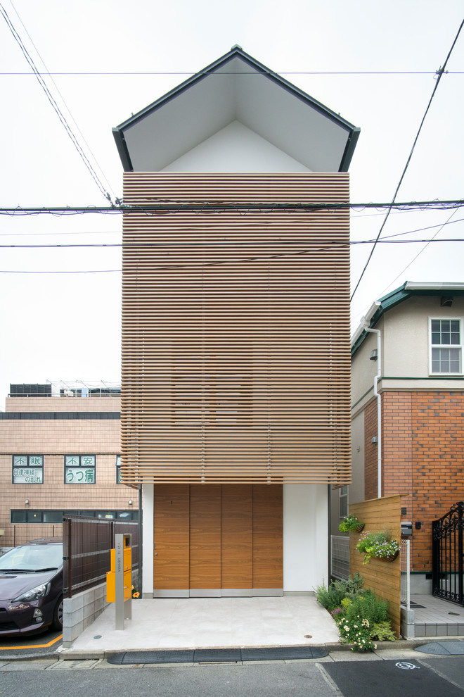 Ejemplo de fachada de casa blanca de estilo zen pequeña con revestimiento de estuco, tejado a dos aguas y tejado de metal