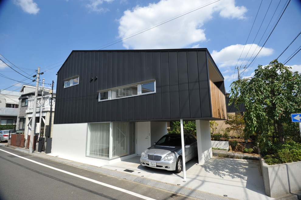 Idéer för att renovera ett mellanstort funkis svart hus i flera nivåer, med metallfasad, halvvalmat sadeltak och tak i metall