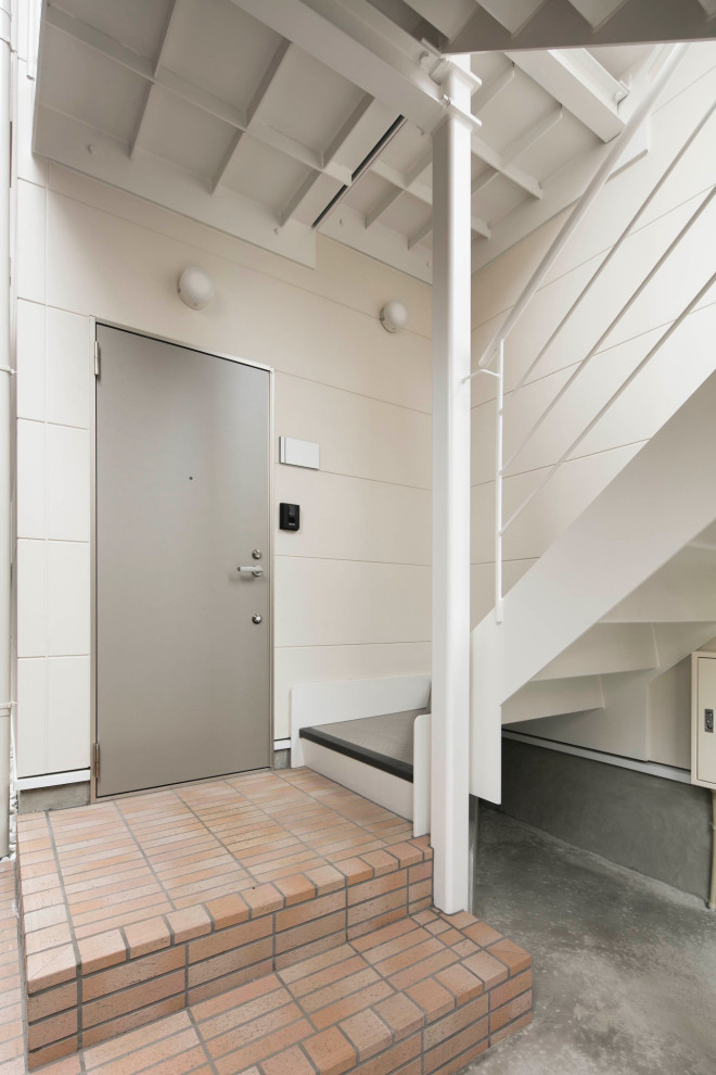 Kleines, Dreistöckiges Skandinavisches Einfamilienhaus mit Faserzement-Fassade, weißer Fassadenfarbe, Satteldach und Blechdach in Tokio
