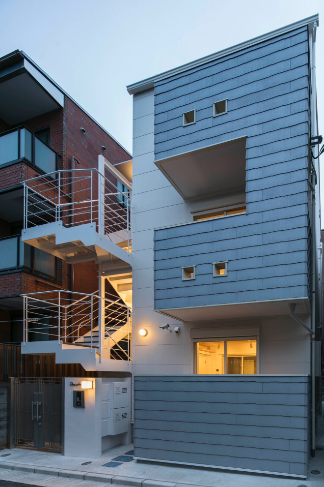 Imagen de fachada de casa blanca escandinava pequeña de tres plantas con revestimiento de aglomerado de cemento, tejado a dos aguas y tejado de metal
