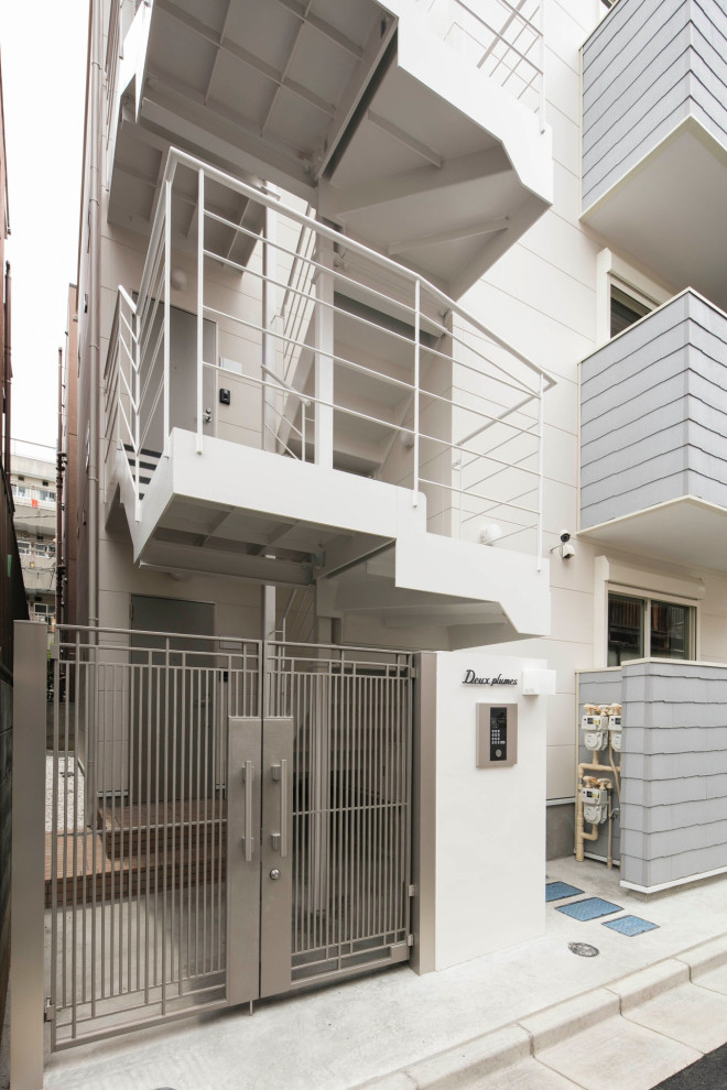 Photo of a small and white scandi detached house in Tokyo with three floors, concrete fibreboard cladding, a pitched roof and a metal roof.