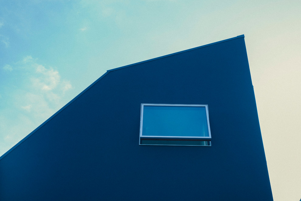 Aménagement d'une façade de maison bleue moderne de taille moyenne et à deux étages et plus avec un toit en appentis.
