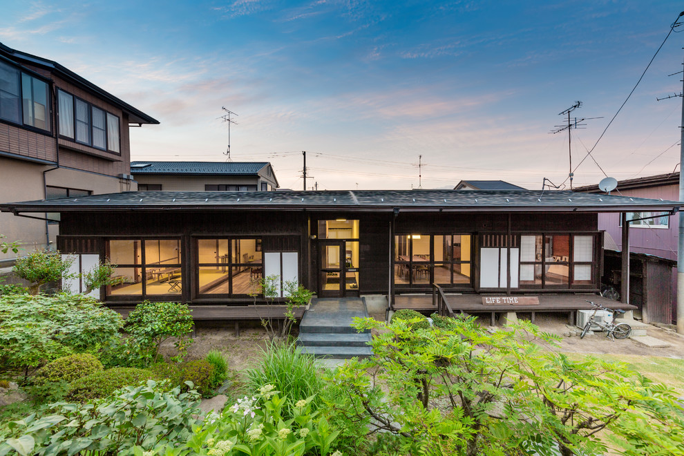 Mittelgroßes, Einstöckiges Asiatisches Einfamilienhaus mit brauner Fassadenfarbe und Schindeldach in Sonstige