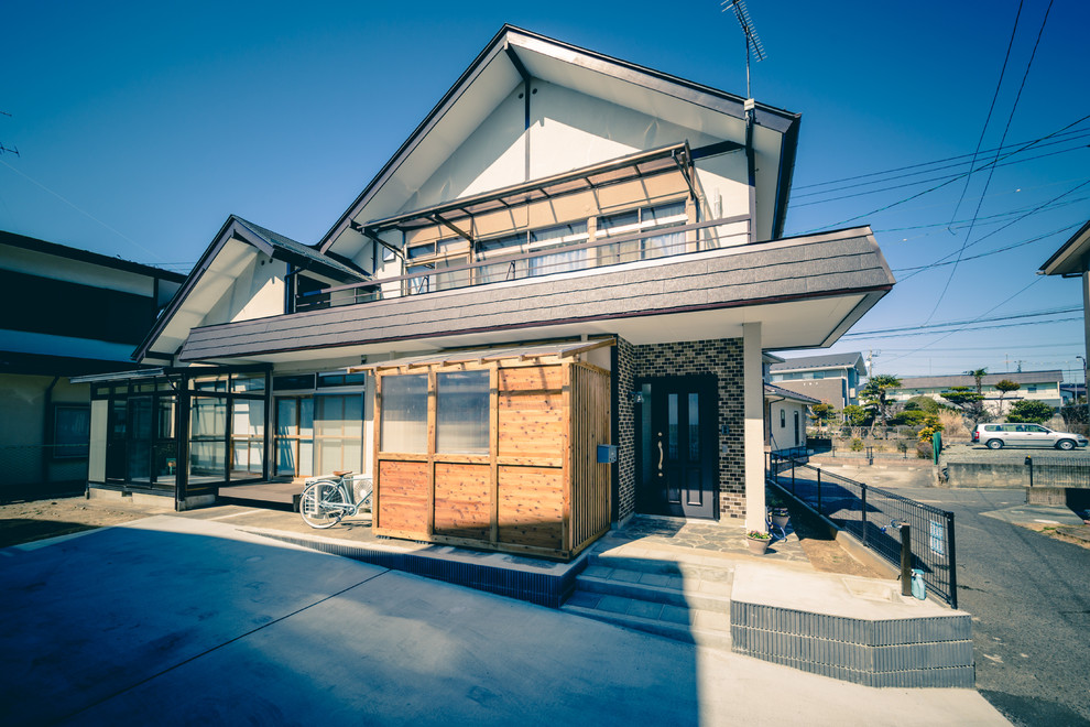 Kleines Asiatisches Einfamilienhaus mit Betonfassade, weißer Fassadenfarbe, Flachdach und Misch-Dachdeckung in Sonstige