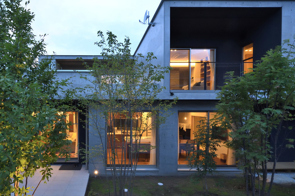 Modelo de fachada gris moderna de dos plantas con revestimiento de hormigón y tejado plano