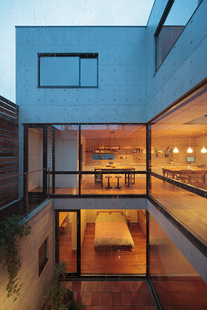 Dreistöckiges Industrial Haus mit Betonfassade, grauer Fassadenfarbe und Flachdach in Tokio