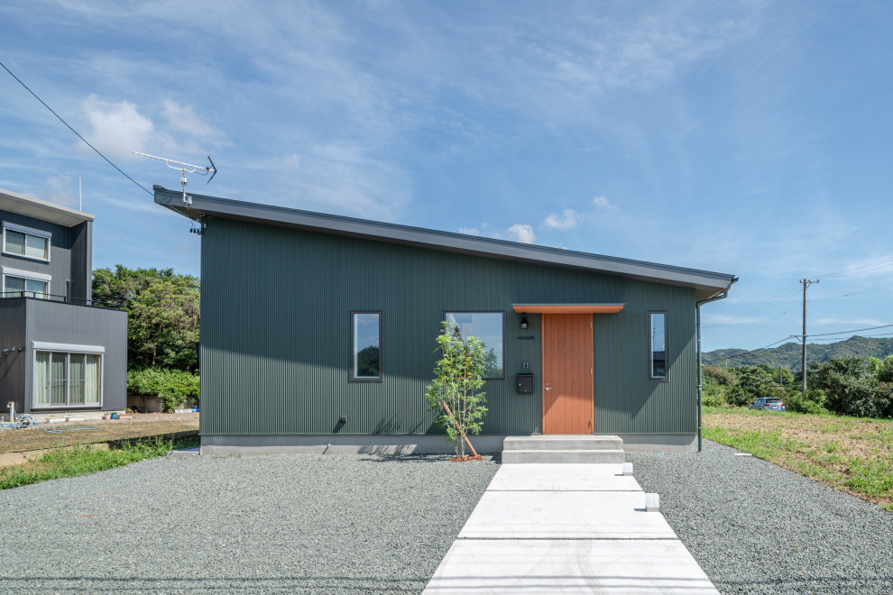 Ejemplo de fachada de casa verde y gris escandinava de tamaño medio de una planta con tejado de un solo tendido, tejado de metal, revestimiento de metal y panel y listón