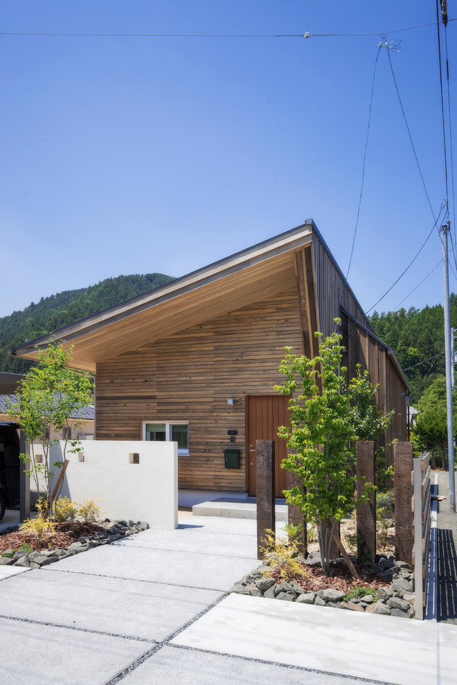 Ispirazione per la facciata di una casa marrone contemporanea a un piano con rivestimento in legno