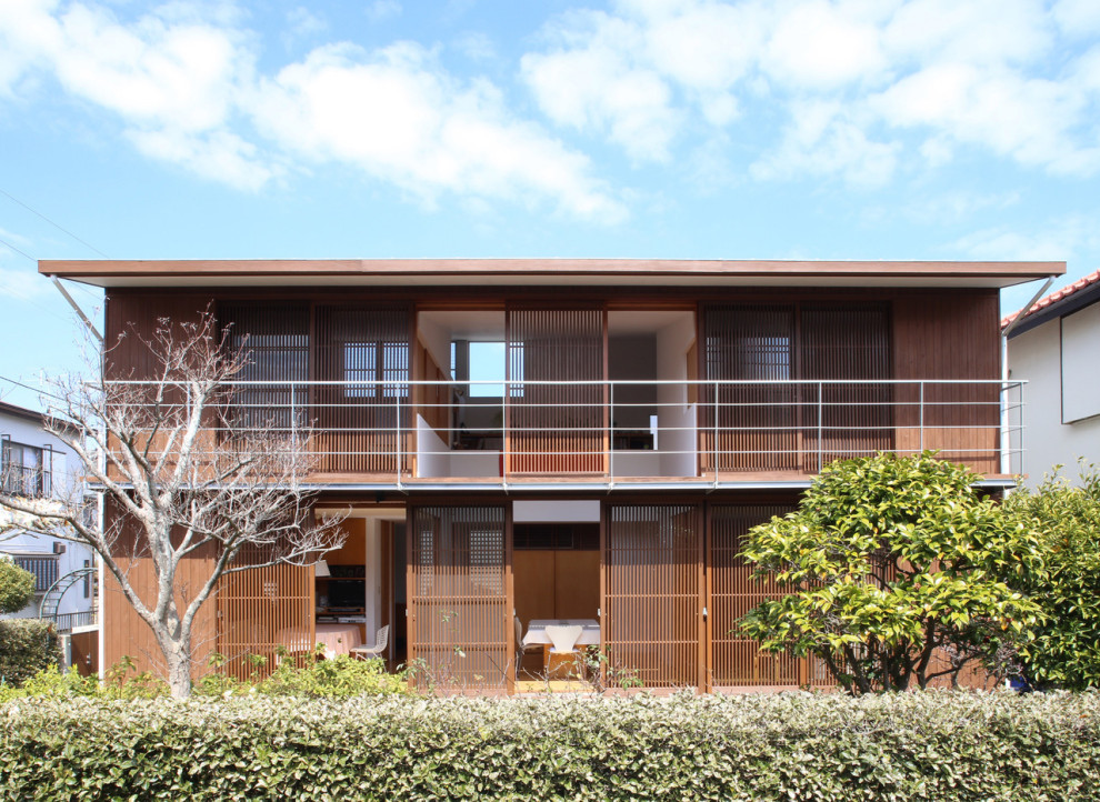 Modelo de fachada de casa marrón asiática de dos plantas con tejado plano