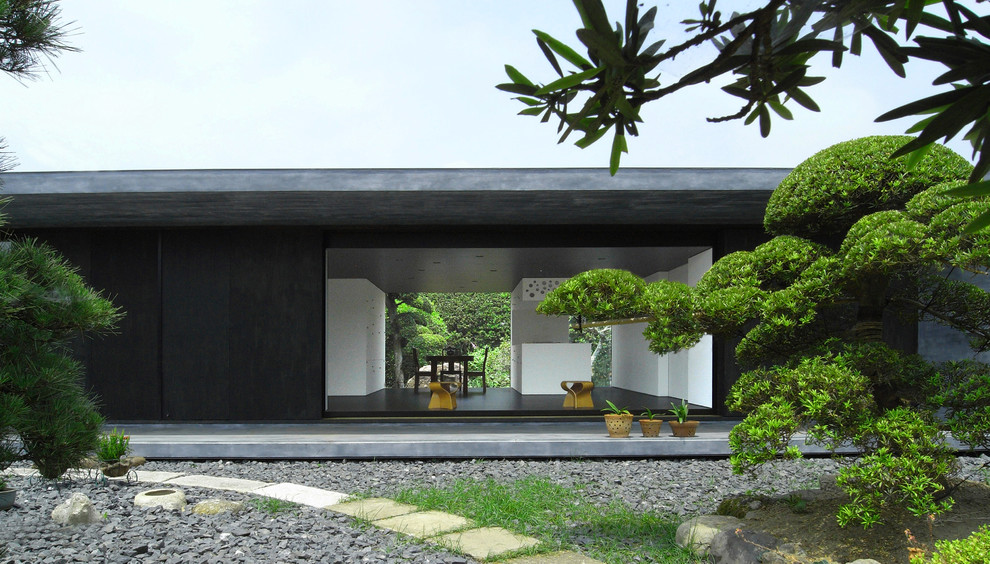 Foto de fachada negra de una planta con revestimiento de madera y tejado plano