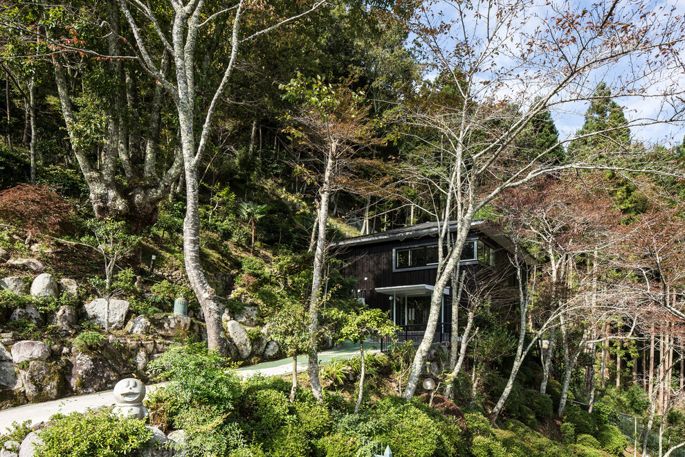 Große, Zweistöckige Moderne Holzfassade Haus mit schwarzer Fassadenfarbe und Blechdach in Kyoto