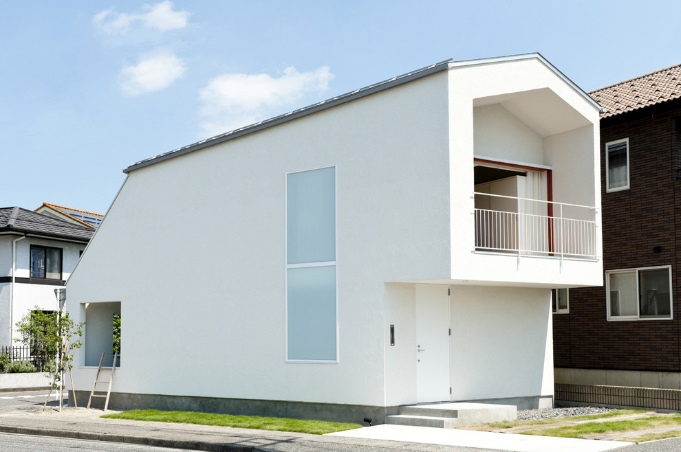Réalisation d'une façade de maison blanche design avec un toit à deux pans.