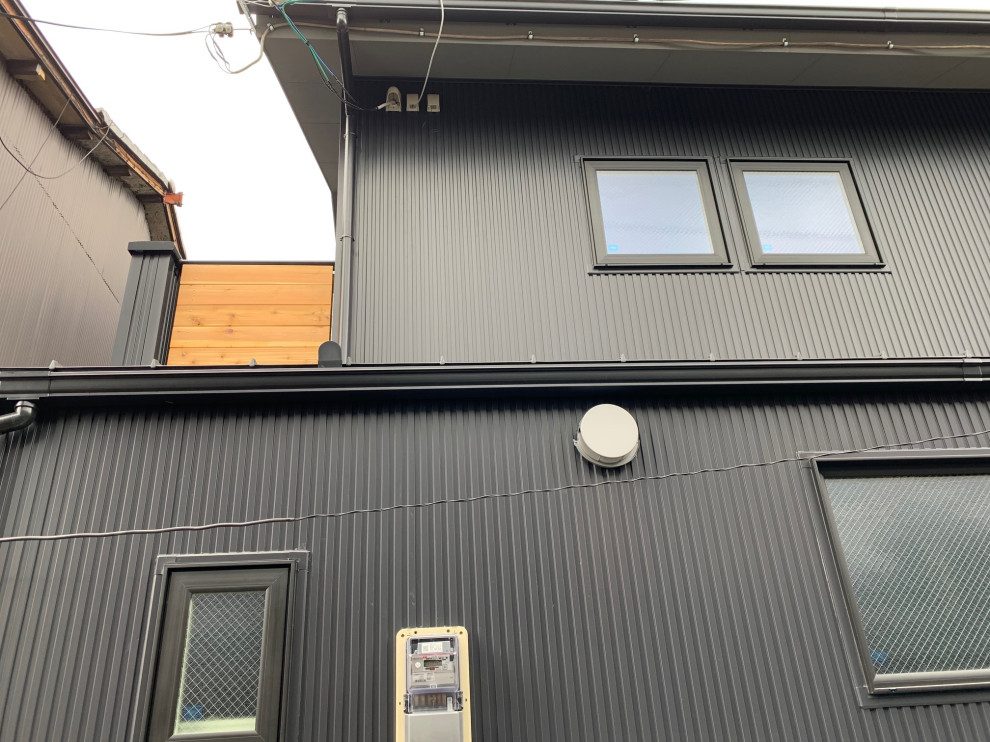 Zweistöckiges Modernes Einfamilienhaus mit Metallfassade, schwarzer Fassadenfarbe, Satteldach und Blechdach in Kyoto