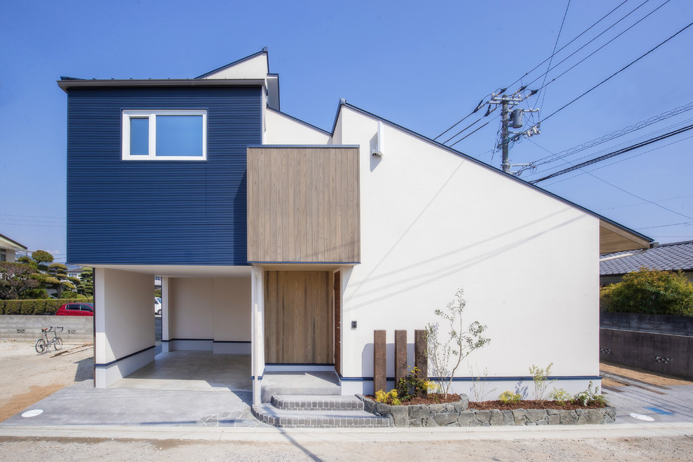 Imagen de fachada de casa multicolor asiática de dos plantas con revestimientos combinados y tejado de un solo tendido