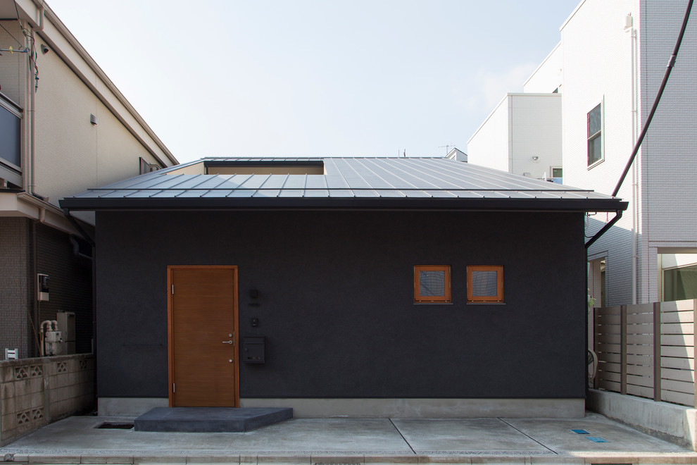 Black and small world-inspired bungalow house exterior in Tokyo with a pitched roof.