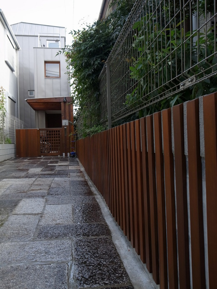 Kleines, Dreistöckiges Modernes Einfamilienhaus mit Metallfassade, grauer Fassadenfarbe, Walmdach und Blechdach in Tokio